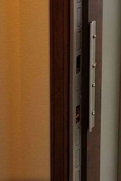 Satin nickel jamb shield and pry shield installed on a door frame